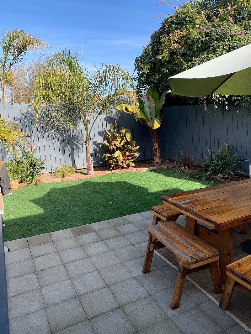 Tropical backyard with picnic table and umbrella