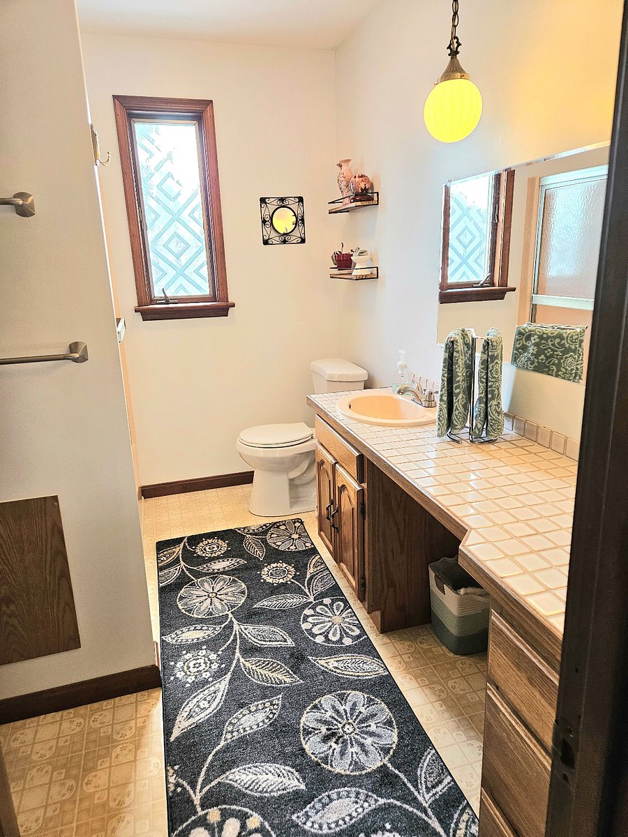 bath with full shower, vanity, and storage
