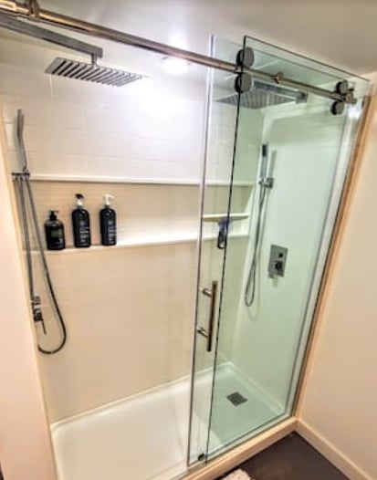 You will not want to leave this shower! Double, huge waterfall showerheads, each with a handheld wand, yummy Body Shop bath gel, and a cozy plush rug.
