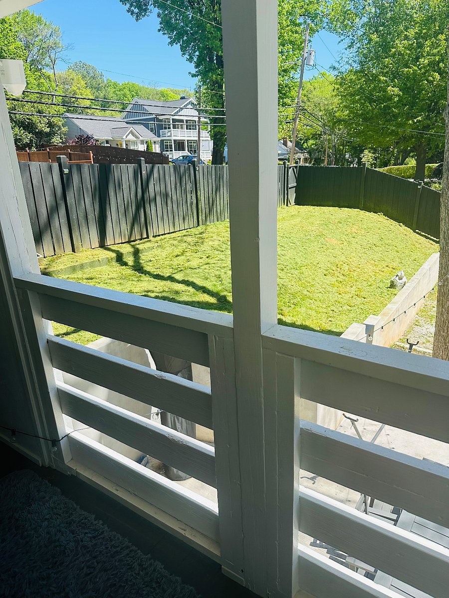 Covered porch overlooking fenced in backyard.