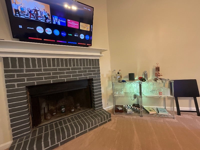 Fireplace stocked with candles and bar area.