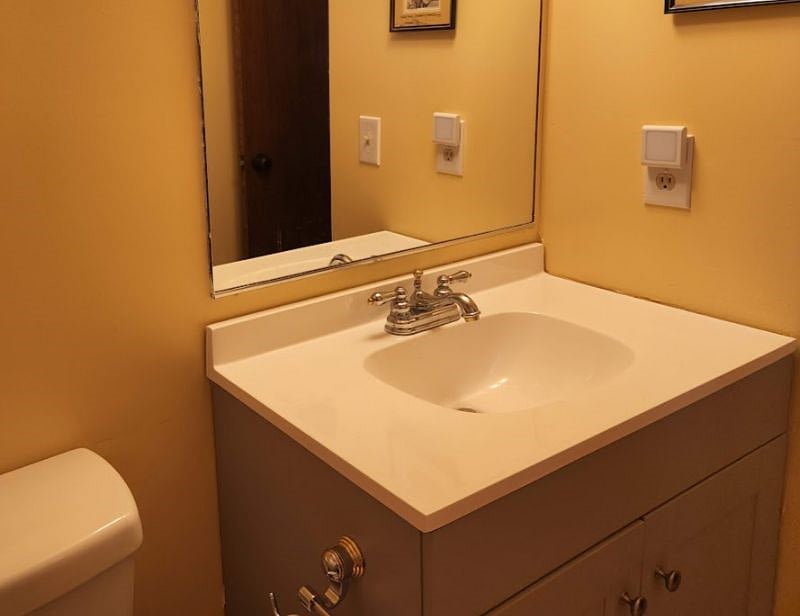 Vanity with large mirror, storage below, next to closet.