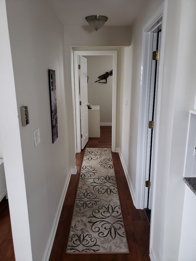 hallway with bathroom on the right followed by a bedroom on the left and bedroom at the end of the hall