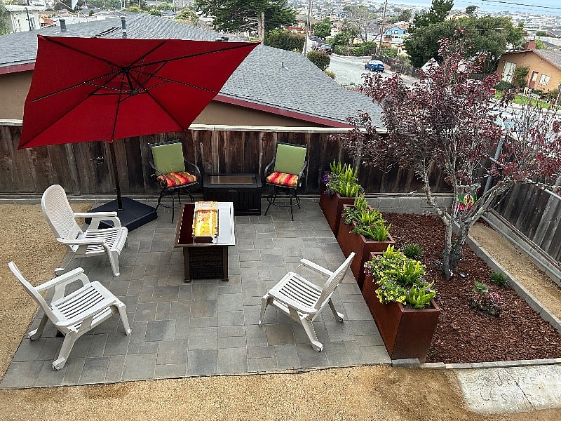 Vibrant courtyard with seating, fire pit, barbecue grill and ocean views.