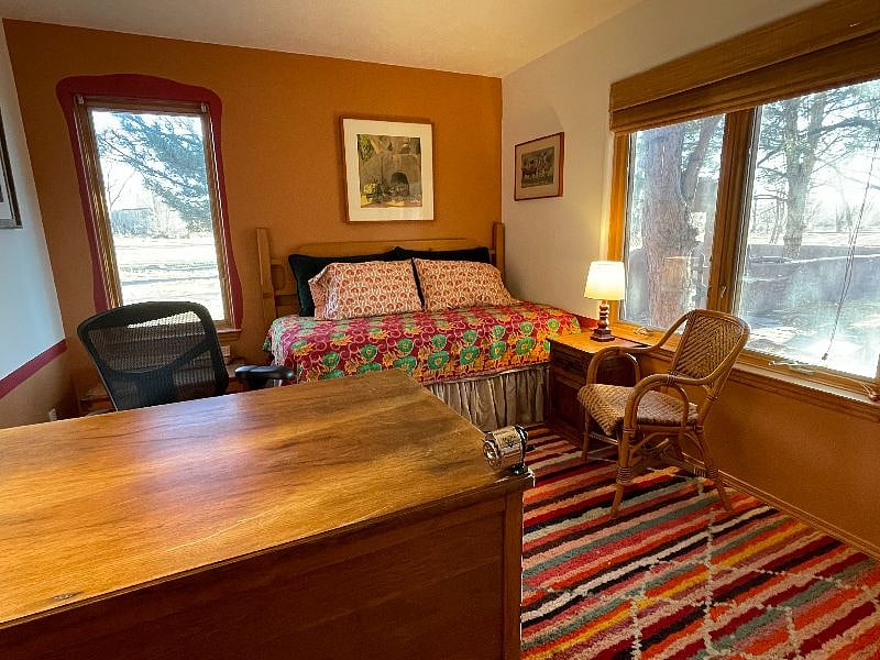 Office with large desk and twin bed