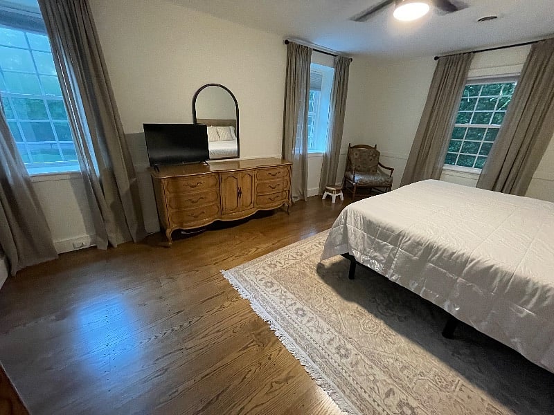 King size bed, TV, two dressers, closet, full size washer/dryer located in hallway between bedroom and private bathroom.