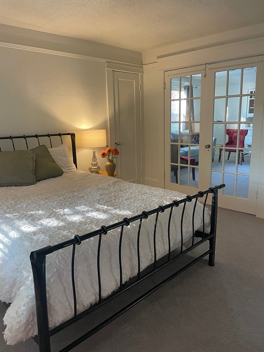 1st bedroom with queen bed. French doors open into living room.