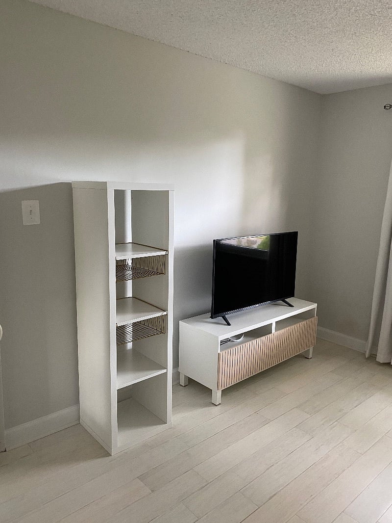 SmartTV and shelves facing the bed.