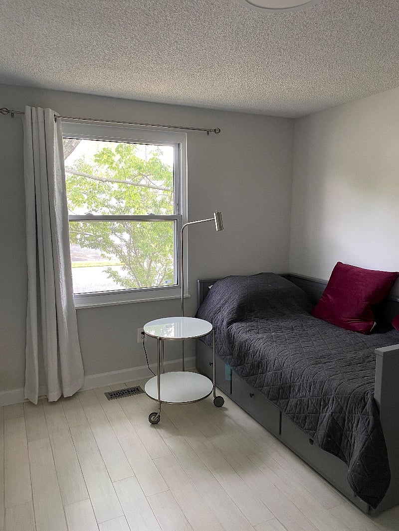 View of the bed and window. The bed extends to a queen size.