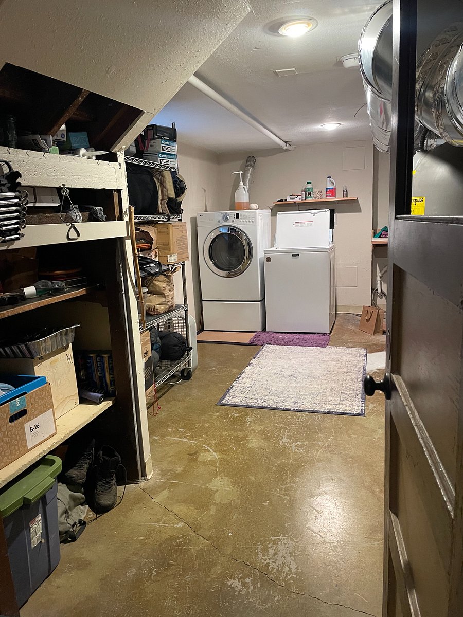 Washer and dryer in shared basement storage space. 