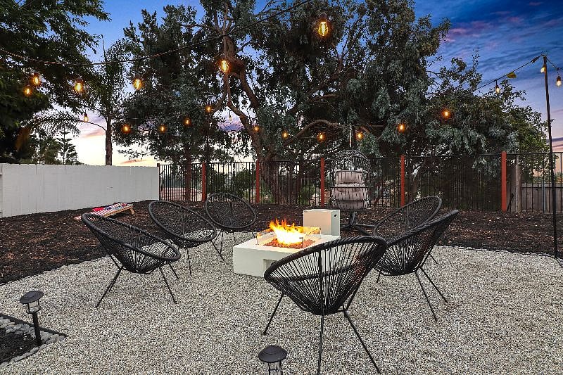 Relax and unwind in the warm glow of the fire pit, surrounded by the natural beauty and tranquility of this inviting backyard oasis - the perfect setting for making memories with friends and family.