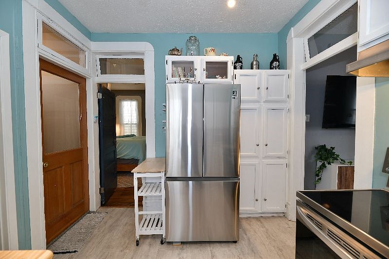 Oversized stainless steel refrigerator with full-size freezer for use. The oven is a conventional oven and also has an air fryer component.