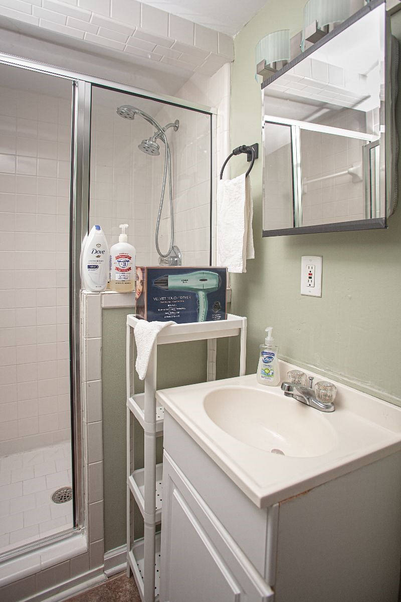 Bathroom with shower, stocked with shampoo, conditioner, body wash, lotion, dental care kits, unscented laundry detergent