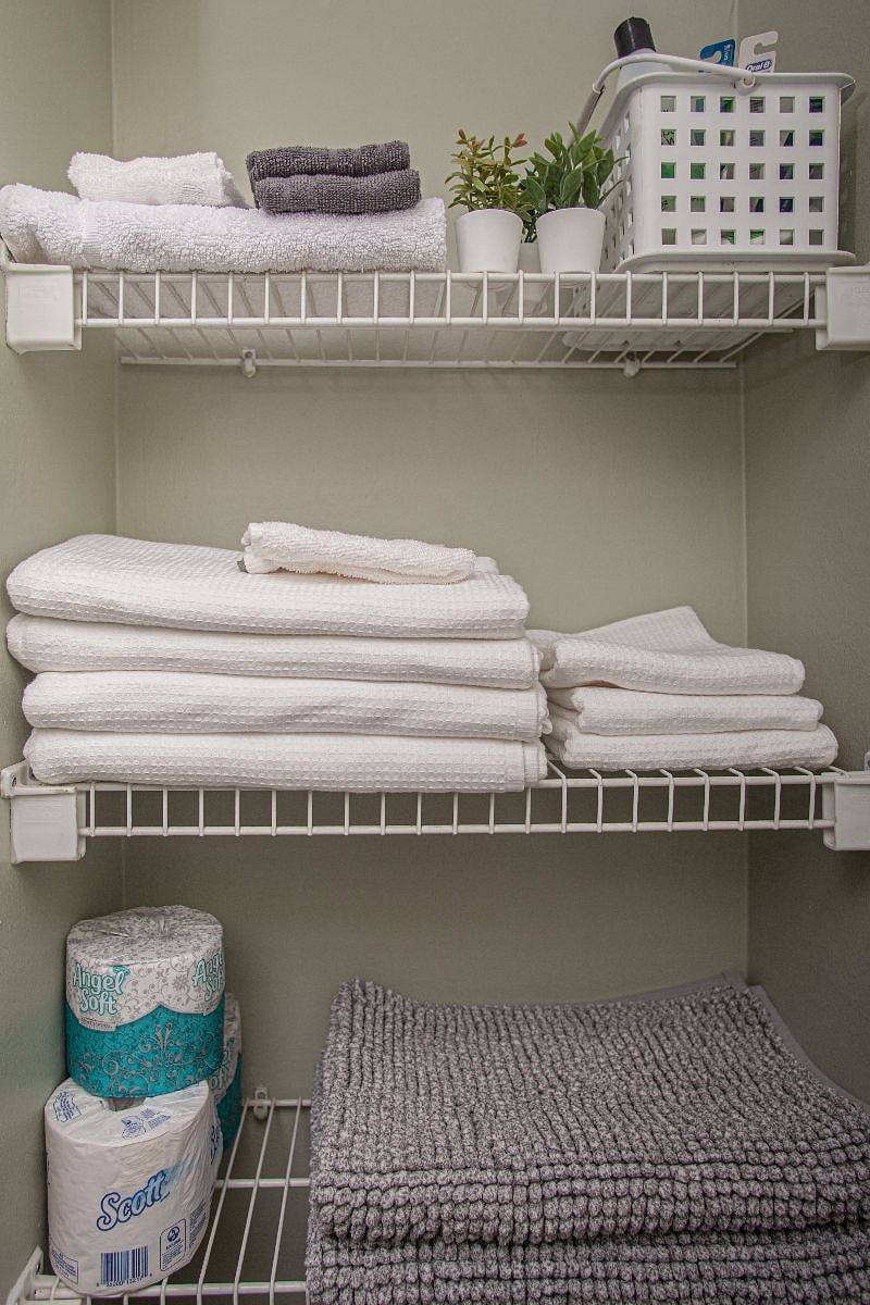 Bathroom stocked with linens, hair dryer and personal care products.