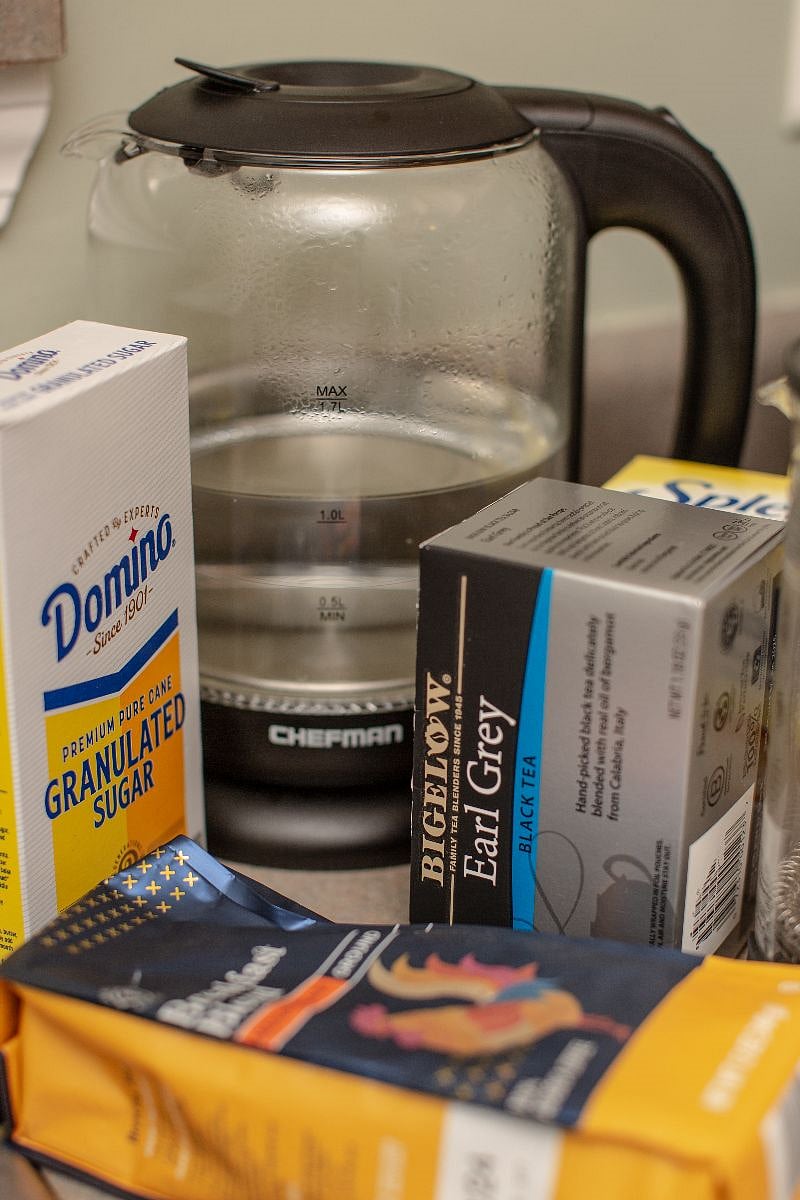 Kitchen stocked with coffee, tea, sweeteners and creamer, oil and condiments.