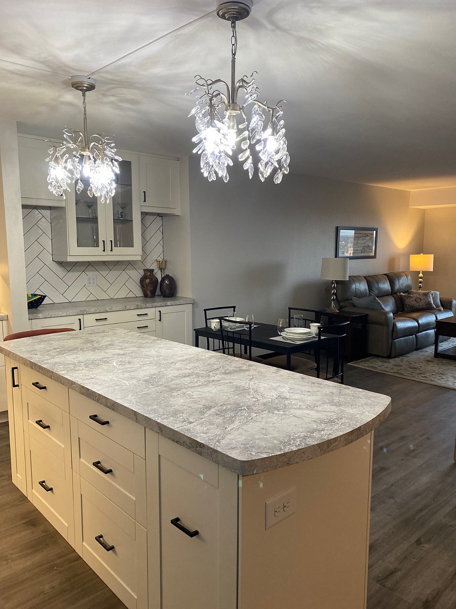 As you enter the condo unit, the large kitchen is to the right, featuring chandelier and undercabinet lighting, as well as plenty of storage.