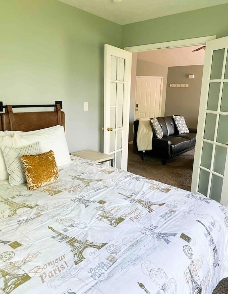 Bedroom off the living room with french doors, closet space, and a queen bed
