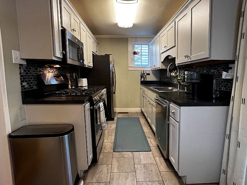 Galley style kitchen with plush standing pad for comfortable cooking.