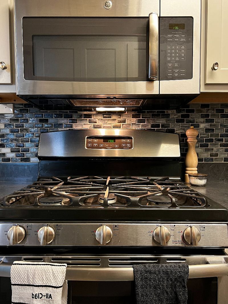 5 burner gas range with microwave above.