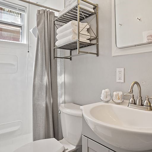 The bathroom includes a bathtub, perfect for relaxing after a long day at work or enjoying a quiet soak during your stay.