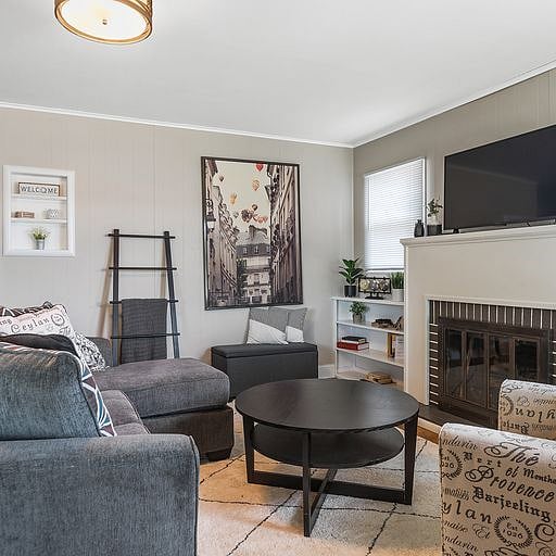 Cozy up by the warm fireplace on the plush sofa, ideal for unwinding or enjoying a quiet evening.