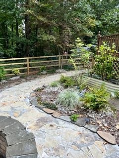 fenced private backyard patio with stone walkway
