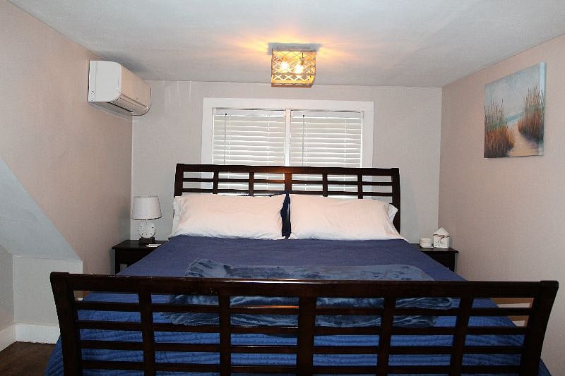 King bed with two night stands and dresser on second floor.