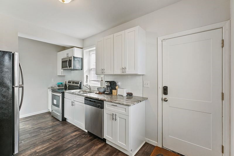 The kitchen in the row home has high-quality stain-steel appliances, cookware, a coffee maker, and all the necessary utensils.