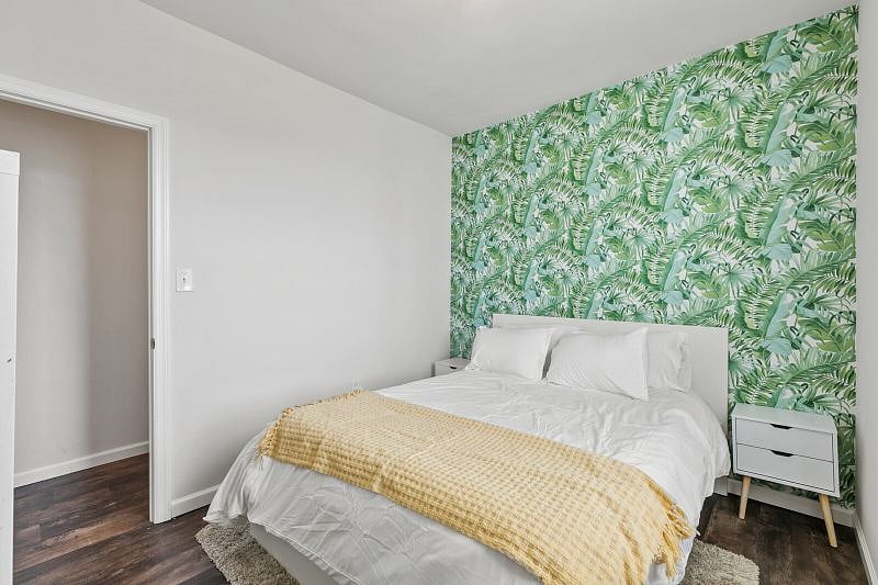 The second bedroom has a unique accent wall & cozy Queen bed.