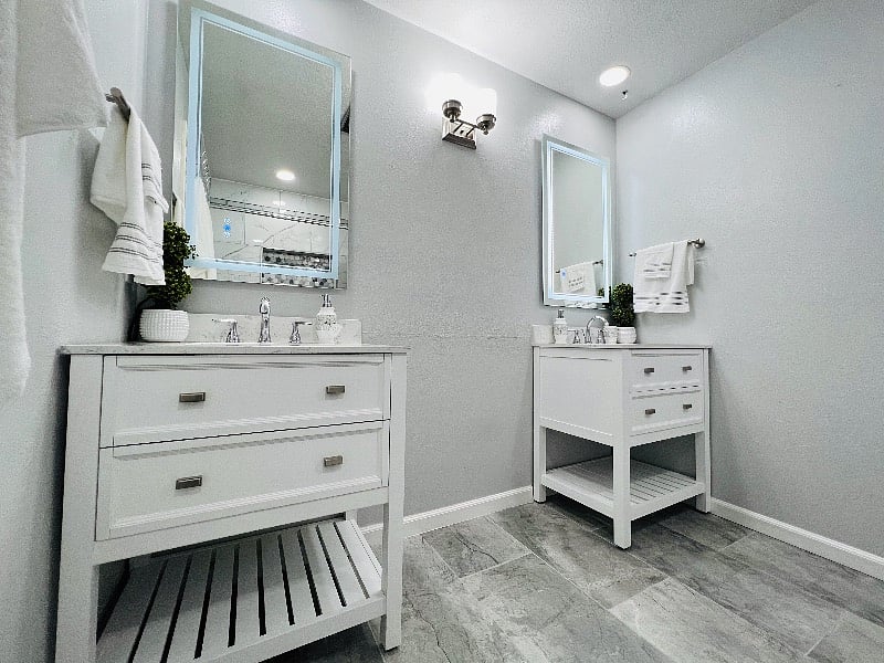 Fully renovated primary bathroom with LED light mirrors and adjustable ceiling lights.