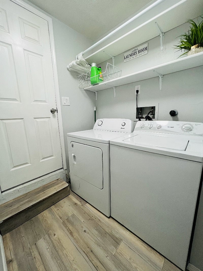 Laundry room with shelves and hanging rod.