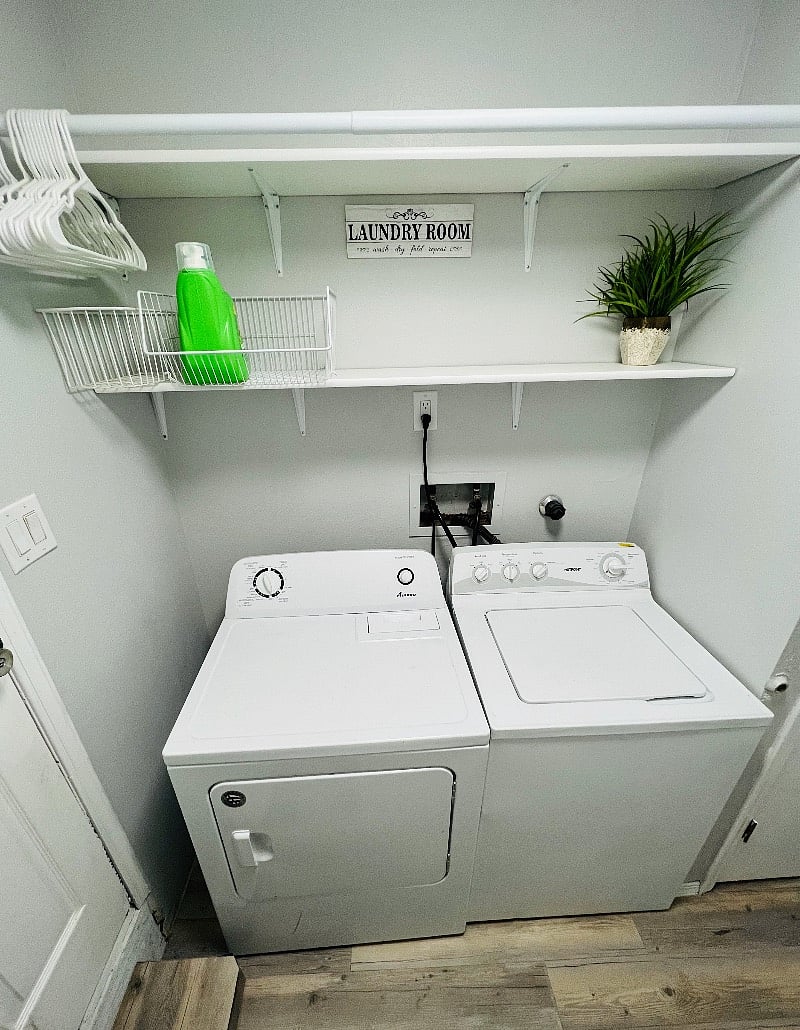 Laundry room with shelves and hanging rod.