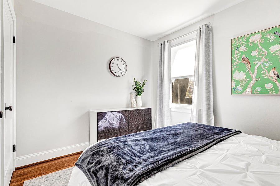 Queen bedroom with blackout curtains and clothing storage, perfect for extended stays.