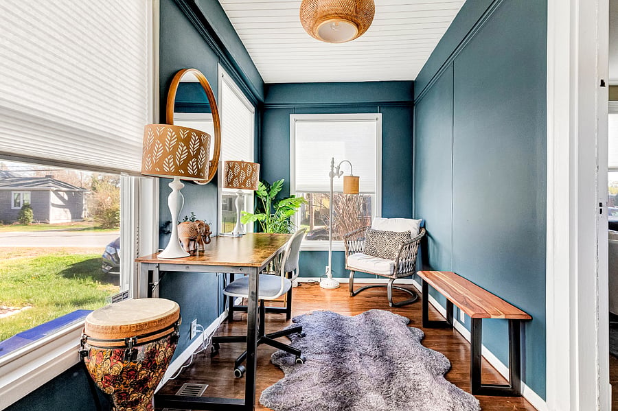 Bohemian-inspired bonus room with rich teal walls and warm lighting, a quiet space for work, relaxing, or creative hobbies.