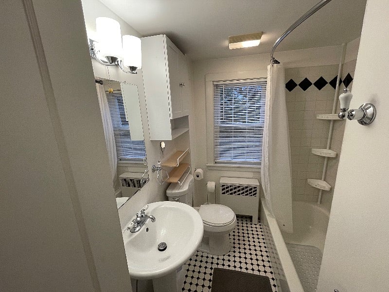 Bathroom with tub and shower and storage cabinets.