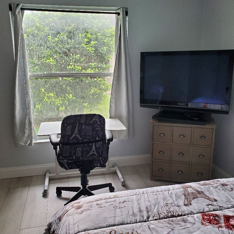 A desk and roomy 5 drawer dresser with a large window for natural light.