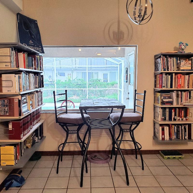 Shared bar height table in the library overlooking the pool