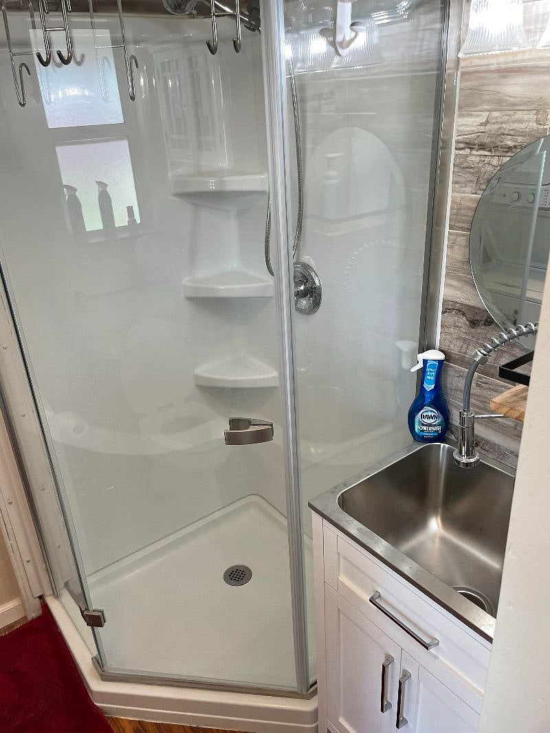 Shower next to deep sink in bathroom.