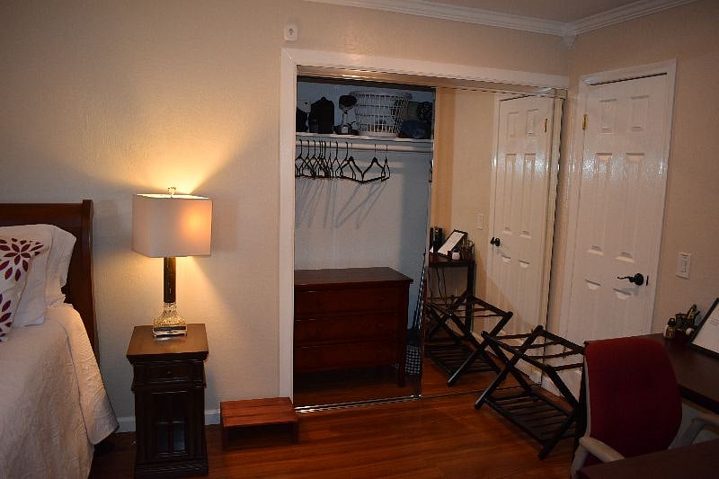 Closet with Dresser, fabric Steamer, Luggage Rack. White door to right is extra storage closet. 