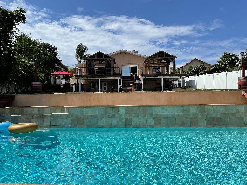 View from pool of covered patio, deck, rental sliding glass doors on deck