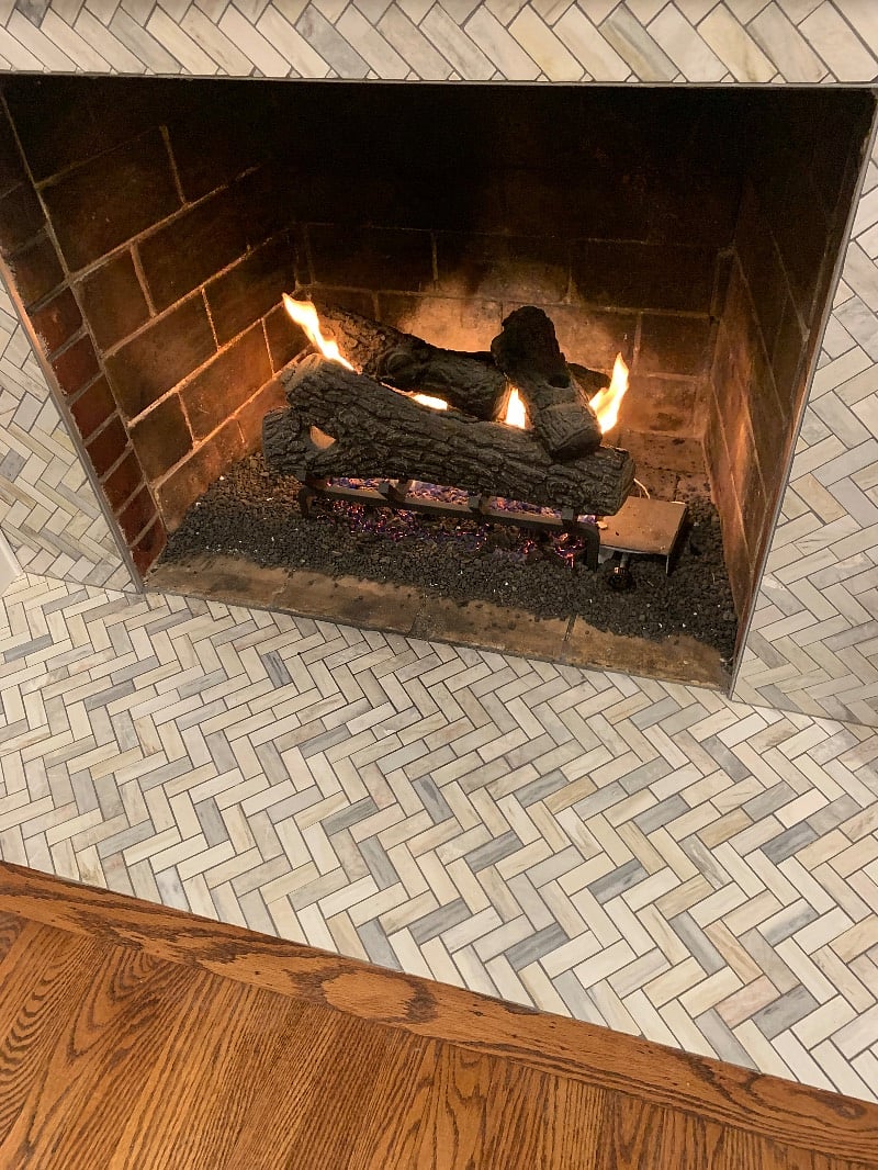 gas fireplace with herringbone surround tile