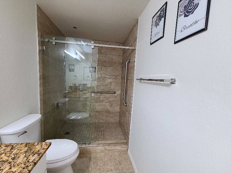 Large walk-in shower with rain and handheld shower.