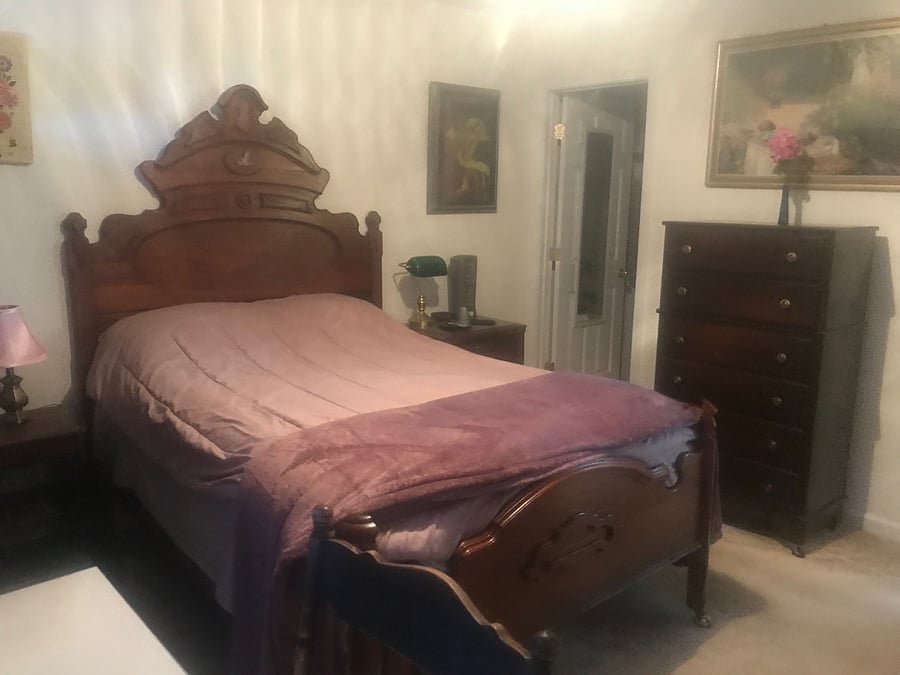 Cozy bedroom has a desk, bookcase, dresser, mini microwave, mini refrigerator and private bathroom. 