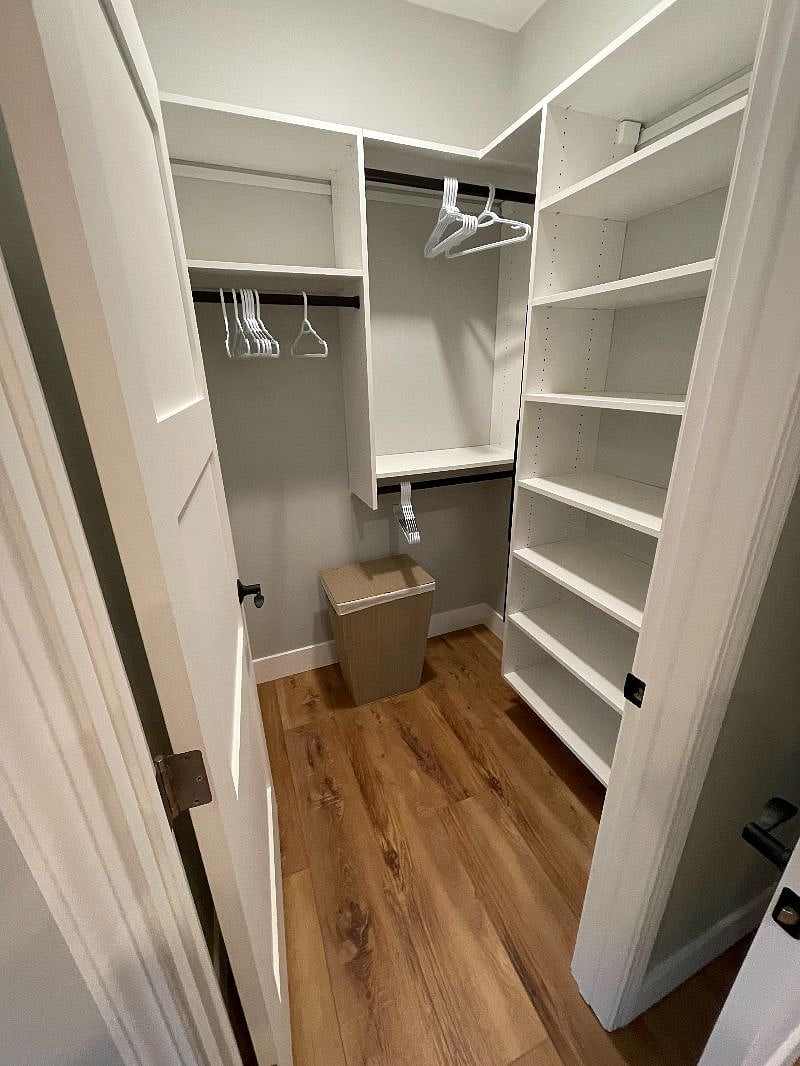 Walk-in closet 1 with plenty of custom shelving and hanging space.
