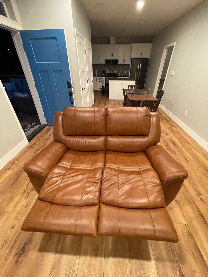 Manual reclining leather loveseat.