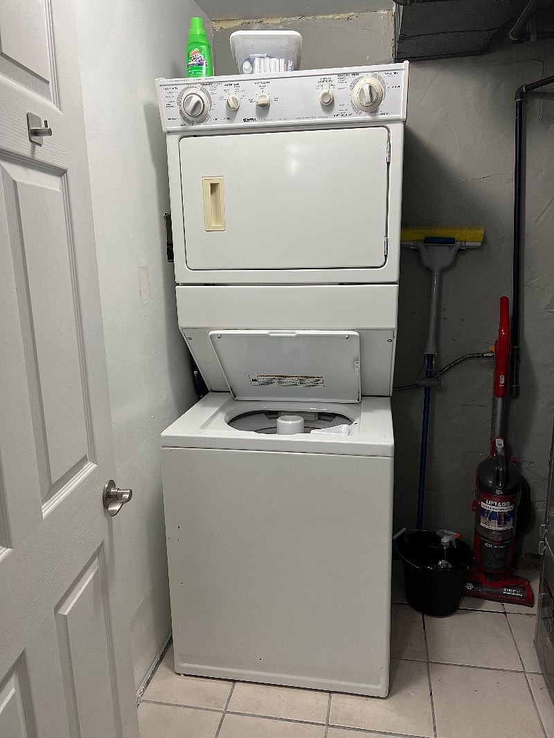 Laundry room that includes a washer and dryer, first aid kit, and cleaning supplies.