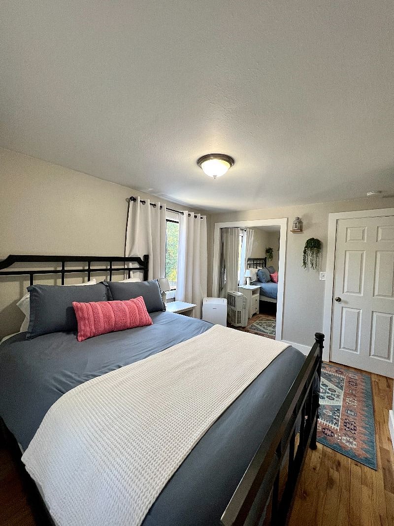 Primary bedroom with blackout curtains and large windows 