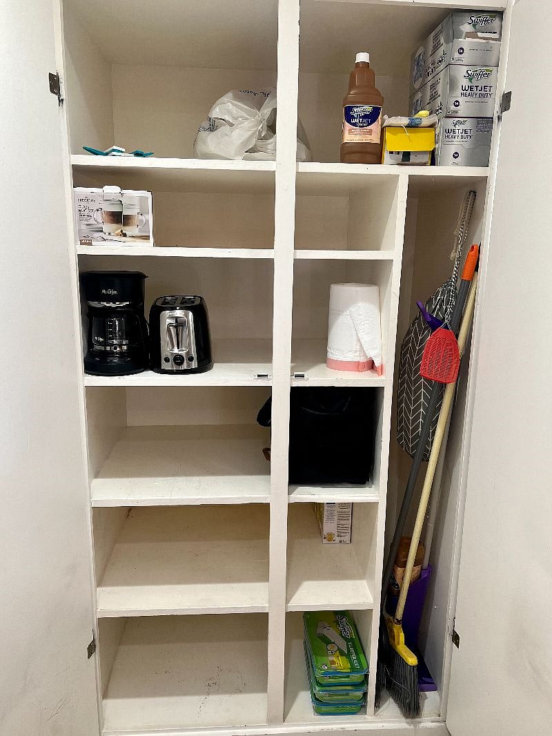 Pantry space including coffee maker, toaster, cleaning supplies, etc. 