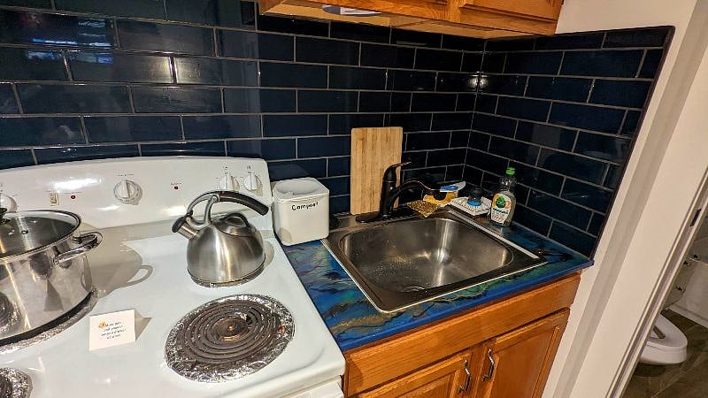 Pots and pans are under the stove.