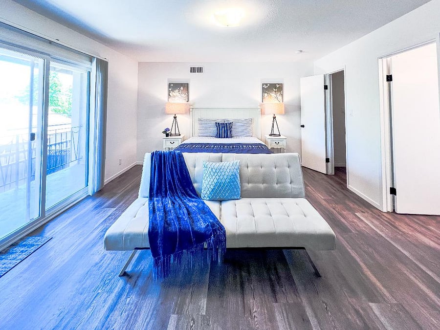 Bedroom - Queen size bed with a couch that folds down to make a twin size bed. Walk-in closet and full bathroom on the right and sliding door to large private balcony on the left.